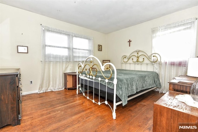 bedroom featuring multiple windows and dark hardwood / wood-style floors