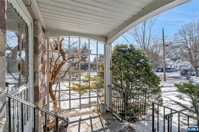 view of snow covered back of property