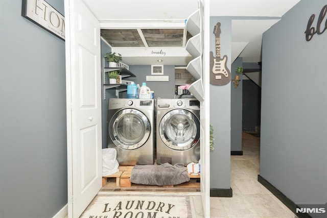 laundry area featuring light tile patterned floors and washer and clothes dryer