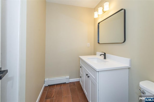 bathroom with vanity, toilet, and a baseboard heating unit