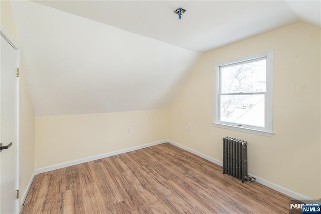 bonus room featuring hardwood / wood-style floors, radiator heating unit, and vaulted ceiling