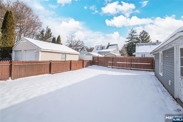 snowy yard featuring a garage