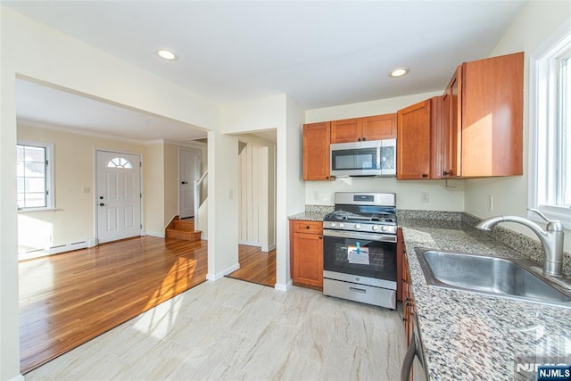 kitchen with sink, stone countertops, and appliances with stainless steel finishes