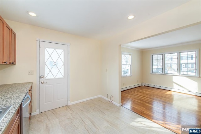 foyer entrance with crown molding, sink, light wood-type flooring, and a baseboard heating unit