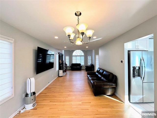 living room featuring an inviting chandelier and light hardwood / wood-style flooring