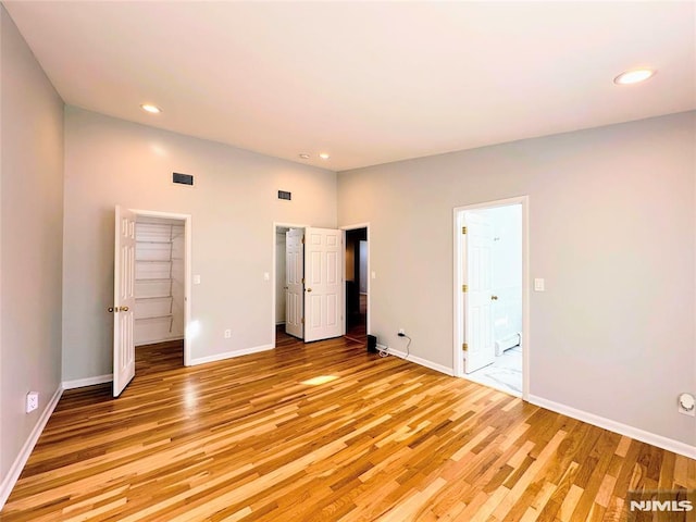 unfurnished bedroom featuring baseboard heating and light wood-type flooring