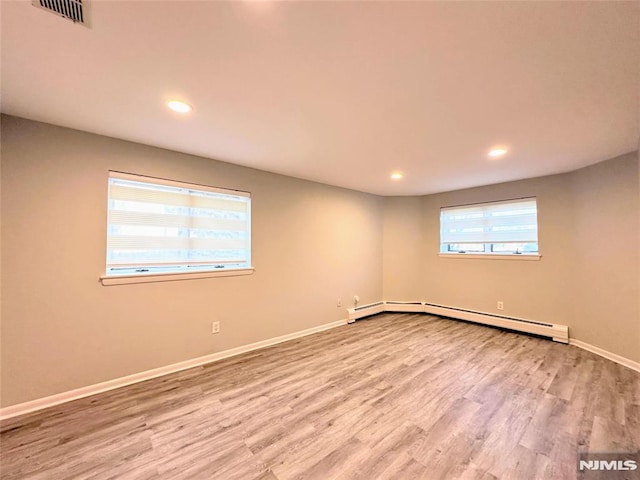 spare room with hardwood / wood-style floors and a baseboard radiator