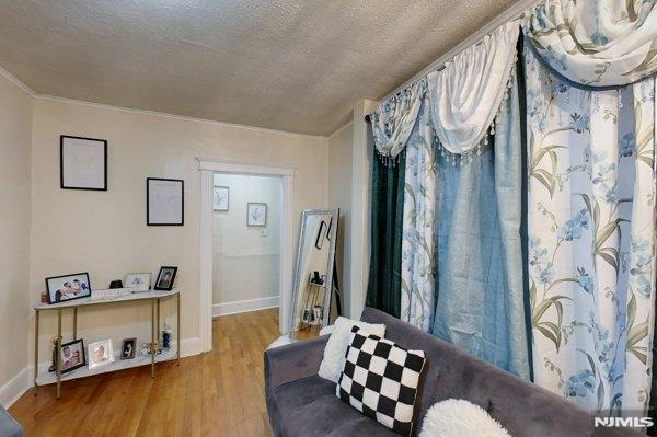 living area with a textured ceiling and hardwood / wood-style floors