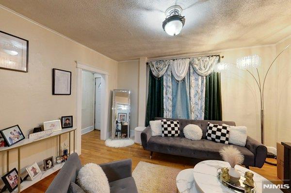 living room with hardwood / wood-style floors and a textured ceiling