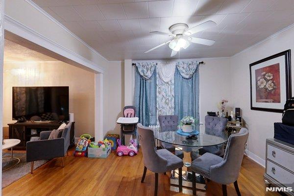 dining room featuring ceiling fan, hardwood / wood-style floors, and crown molding