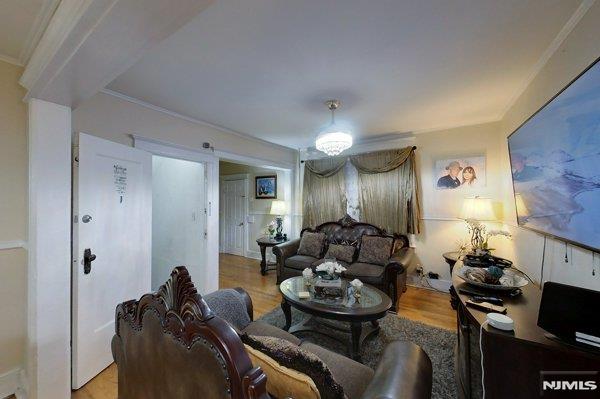 living room featuring light hardwood / wood-style flooring and ornamental molding