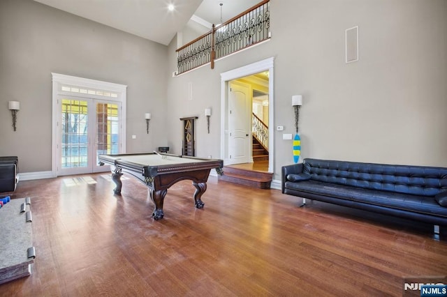 rec room with pool table, hardwood / wood-style floors, high vaulted ceiling, and french doors