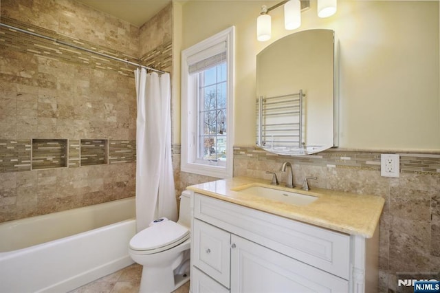 full bathroom with shower / bath combination with curtain, vanity, toilet, and tile walls