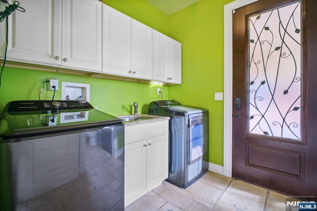 washroom featuring cabinets, sink, and independent washer and dryer