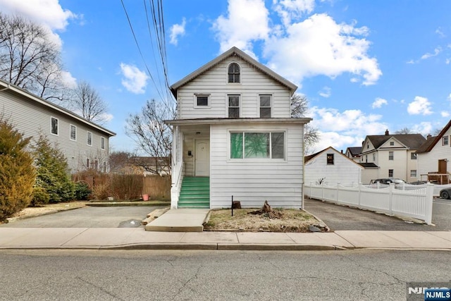 view of front of house featuring aphalt driveway and fence