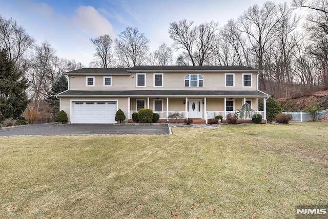 view of front of property with a front lawn, covered porch, and a garage