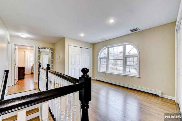 hallway featuring light wood-type flooring and a baseboard radiator