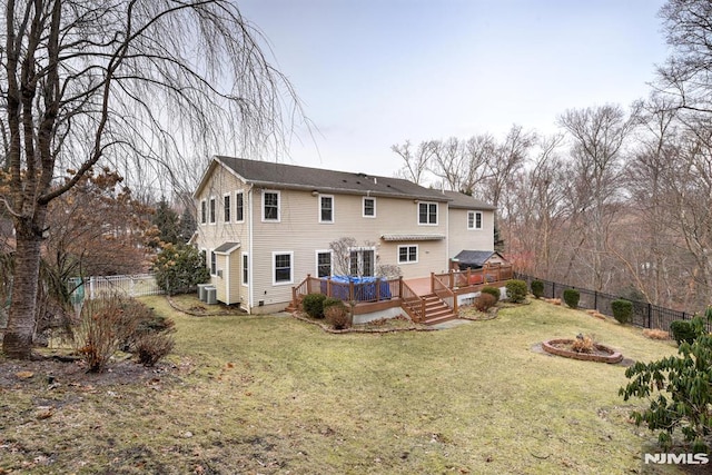 rear view of house with a lawn, central air condition unit, and a wooden deck