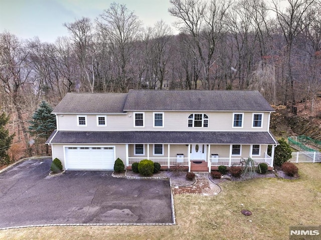 view of front of house with a front lawn, a garage, and a porch