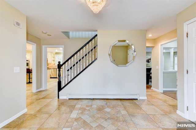 staircase with baseboard heating, an inviting chandelier, and tile patterned flooring