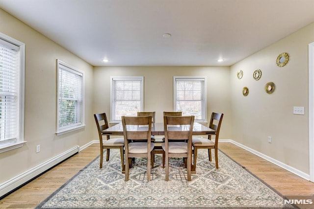 dining room with baseboard heating and light hardwood / wood-style flooring