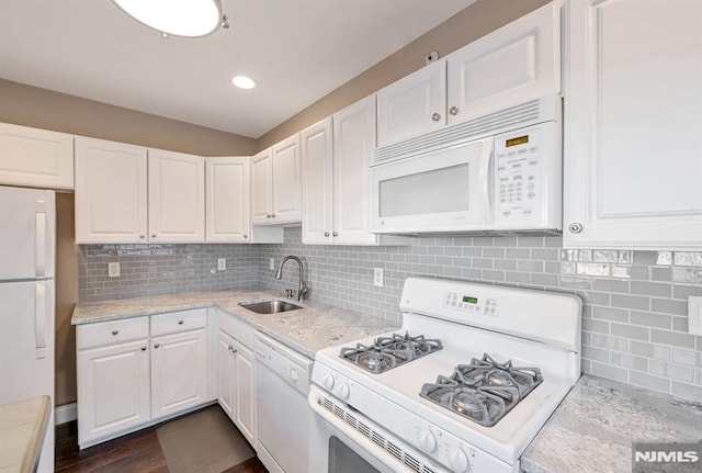 kitchen featuring backsplash, sink, white appliances, and white cabinetry