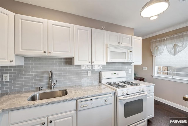 kitchen with backsplash, sink, white appliances, and white cabinetry