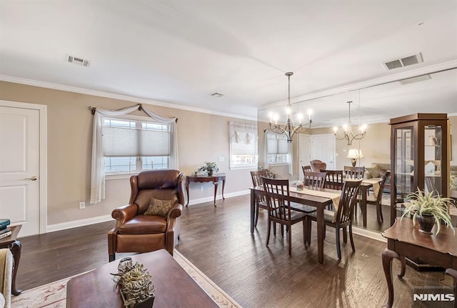 dining space with dark hardwood / wood-style floors, ornamental molding, and an inviting chandelier