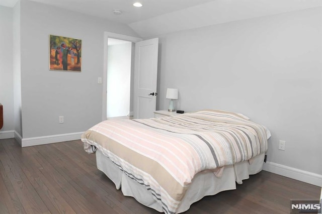 bedroom with vaulted ceiling and dark wood-type flooring