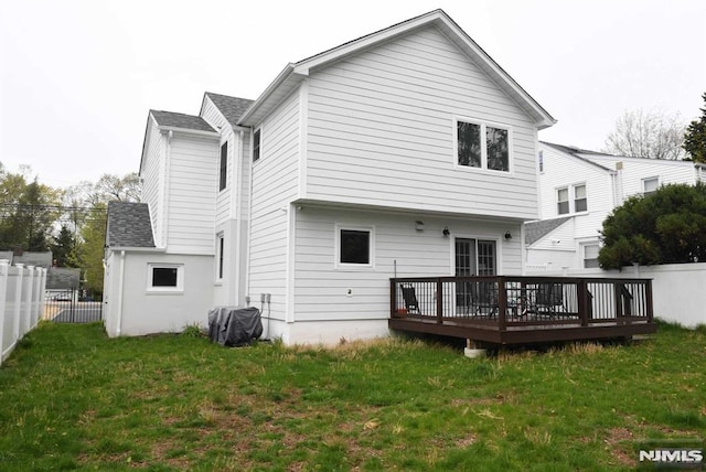 rear view of property featuring a yard and a wooden deck