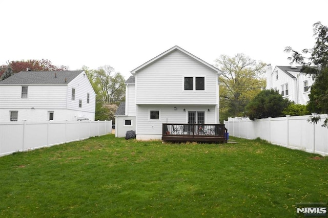 back of house featuring a lawn and a wooden deck