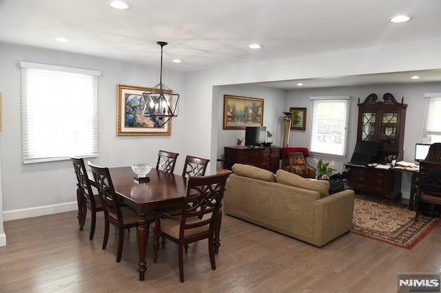 dining room featuring dark wood-type flooring, a chandelier, and a healthy amount of sunlight