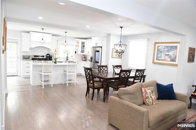 dining space featuring light hardwood / wood-style floors, sink, and a chandelier