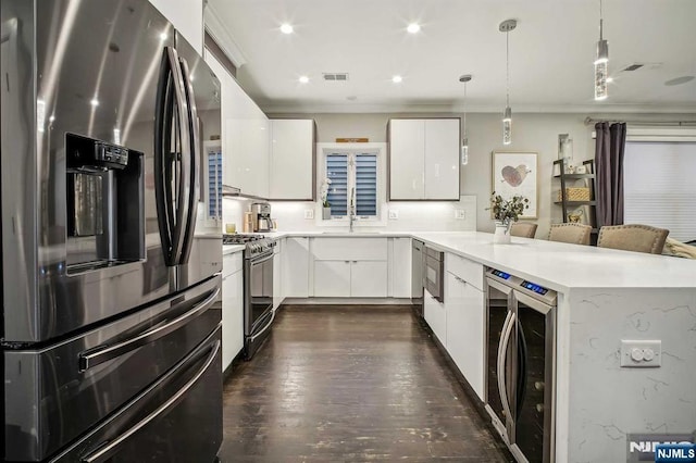 kitchen featuring white cabinetry, pendant lighting, wine cooler, and appliances with stainless steel finishes