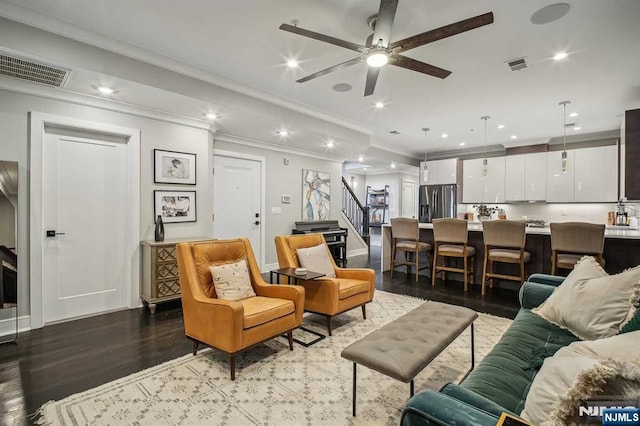 living room with hardwood / wood-style floors, crown molding, and ceiling fan