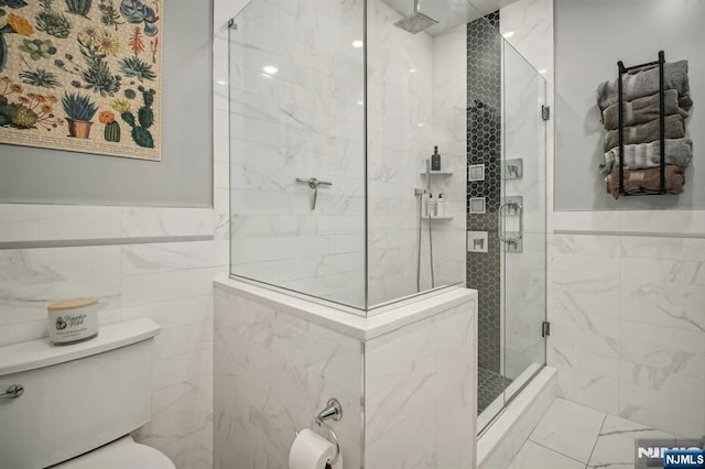 bathroom featuring toilet, tile walls, and a shower with shower door