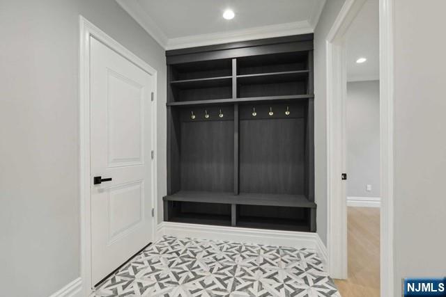 mudroom with crown molding and built in shelves