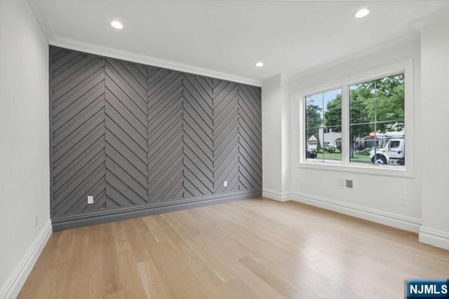 empty room featuring crown molding and light wood-type flooring