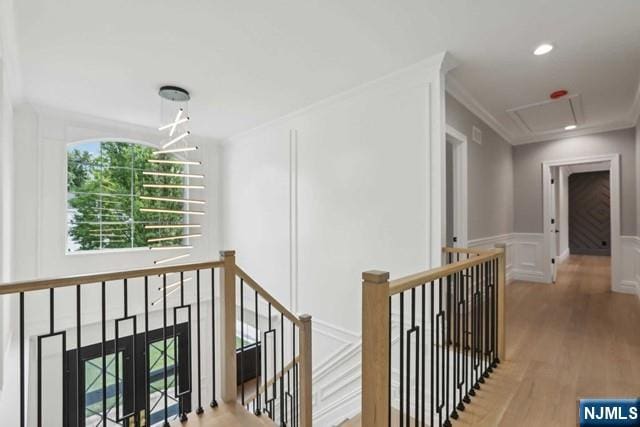 hallway with crown molding and light hardwood / wood-style floors