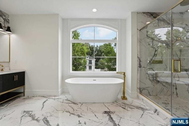 bathroom with vanity and shower with separate bathtub