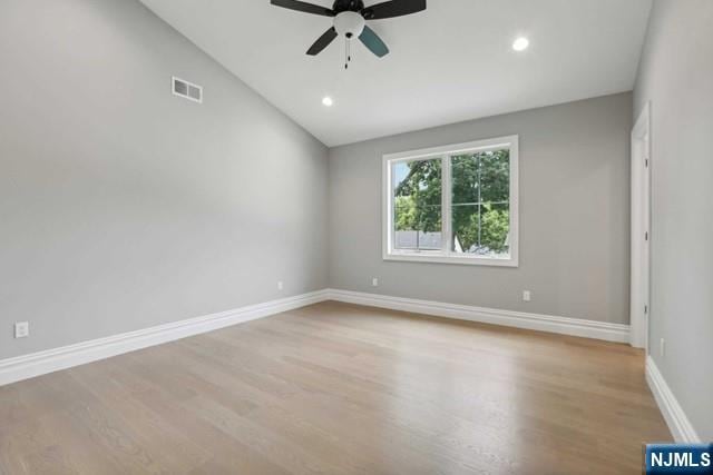 empty room featuring lofted ceiling, ceiling fan, and light wood-type flooring