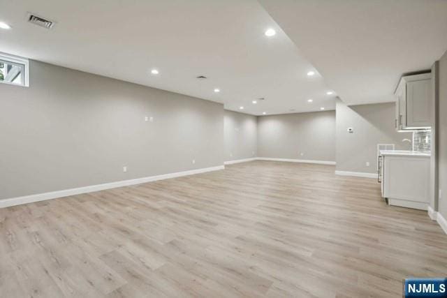 basement with light hardwood / wood-style flooring