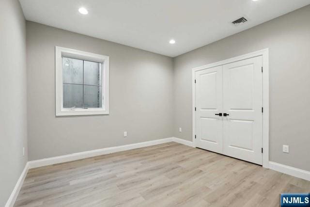 unfurnished bedroom with a closet and light hardwood / wood-style flooring