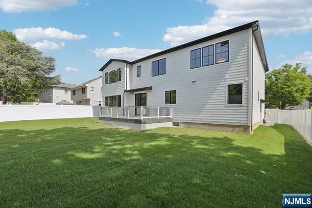 rear view of property featuring a lawn