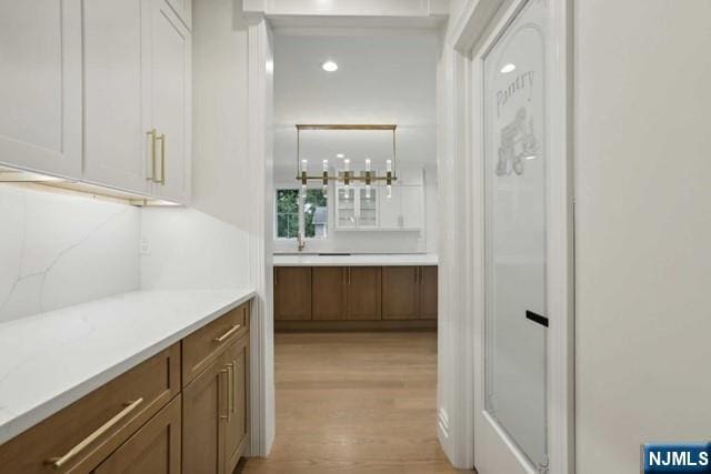 bar featuring backsplash and light wood-type flooring