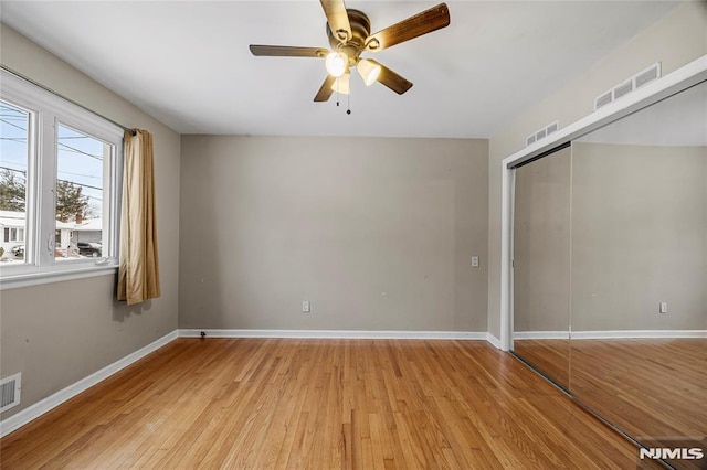 unfurnished bedroom with ceiling fan, a closet, and light wood-type flooring