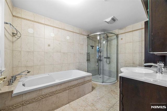 bathroom with tile walls, tile patterned floors, vanity, and shower with separate bathtub