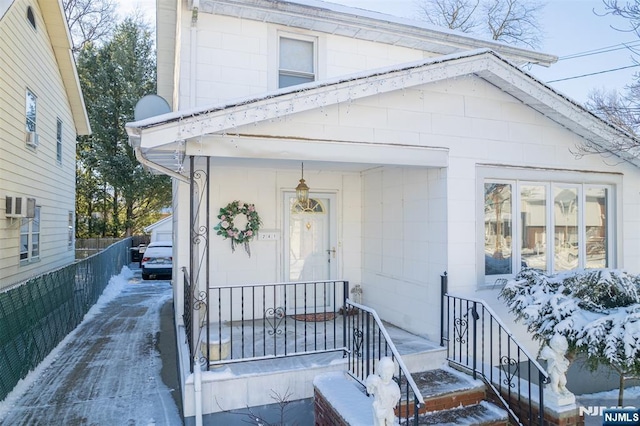 snow covered property entrance featuring a porch