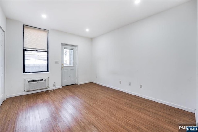 empty room featuring hardwood / wood-style flooring and a wall unit AC