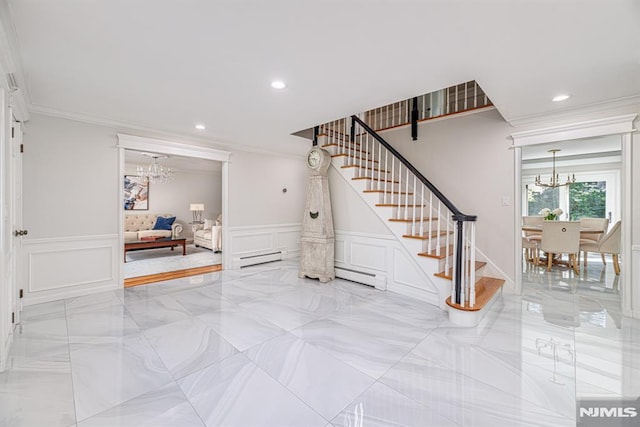 staircase featuring a baseboard heating unit, ornamental molding, and an inviting chandelier